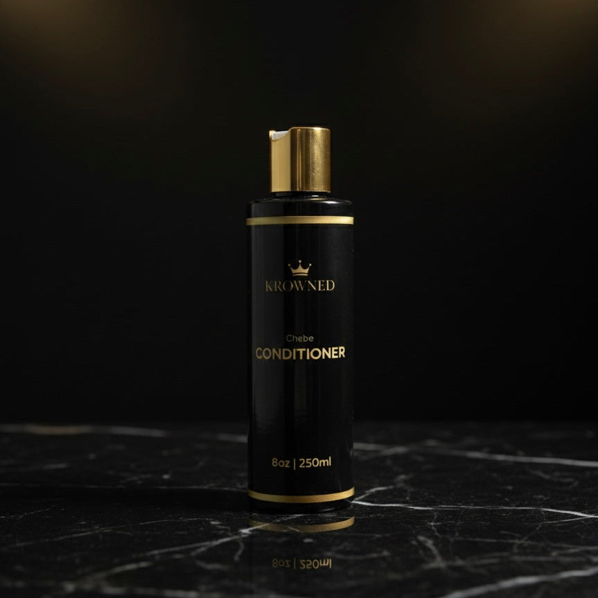 Black conditioner bottle with gold accents on a dark marble surface