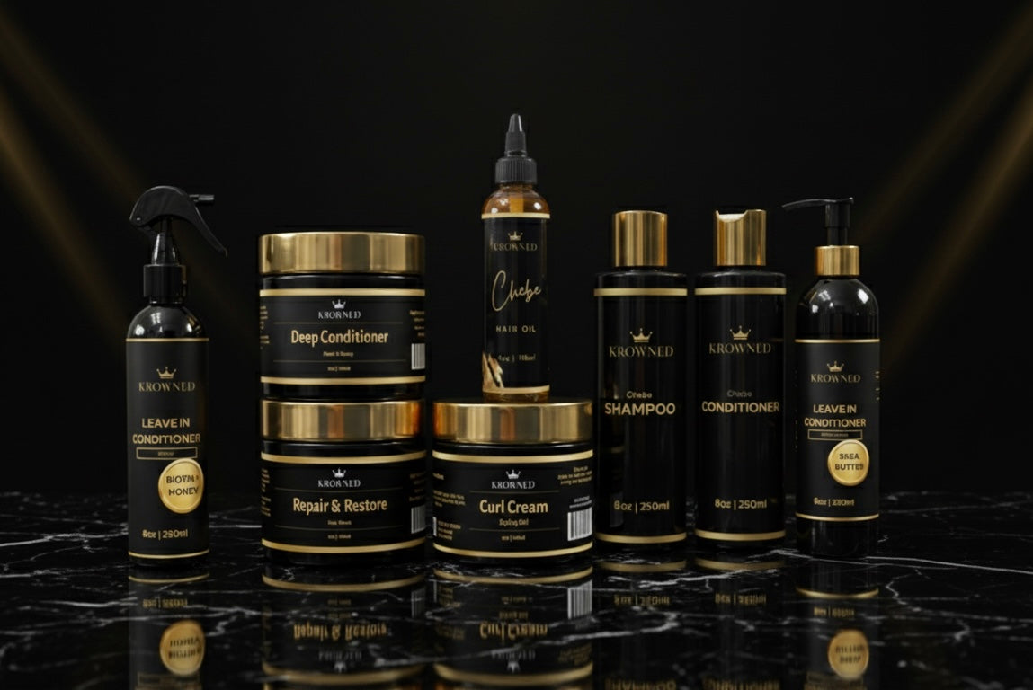 Collection of black hair care products with gold accents on a reflective surface.