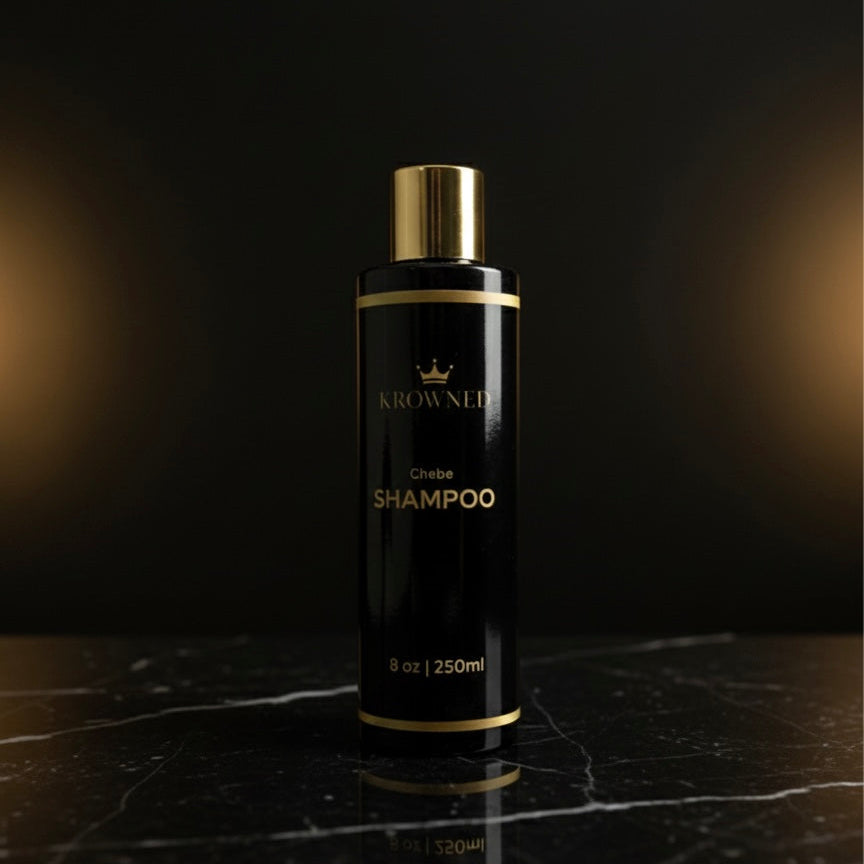 Black shampoo bottle with gold accents on a dark marble surface
